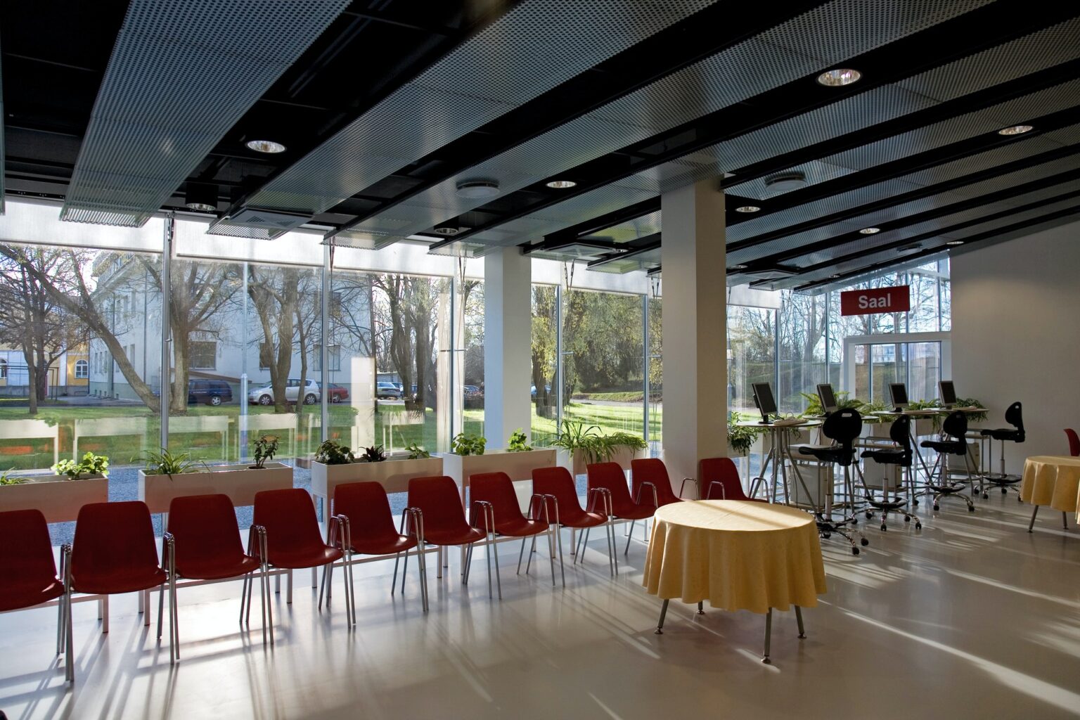 Lobby of hotel or conference centre with chairs and tables set up for event.